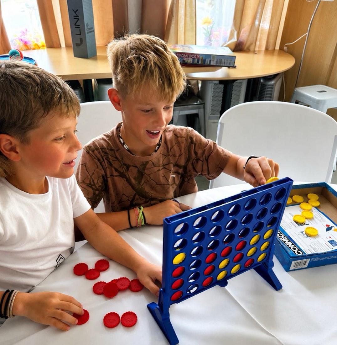 Two campers playing a Connect Four board game